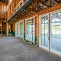 A wooden garage door with vertical panels, surrounded by a brick exterior. The door has a classic design and a warm brown fin